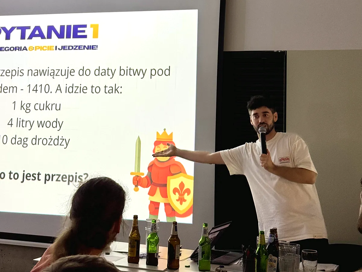 Prowadzący QuizTwist z mikrofonem rozkręca salę